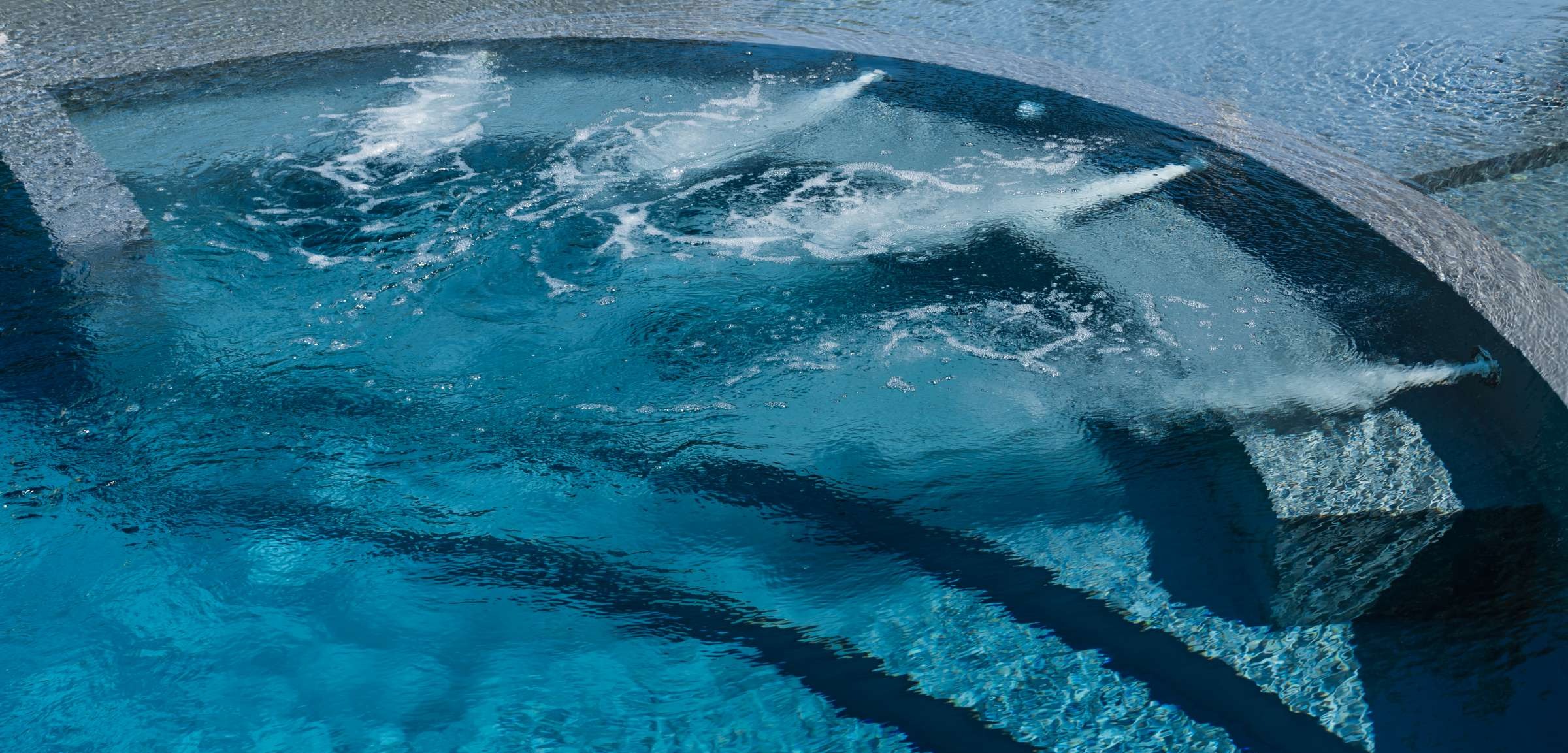 Piscina interrata con rivestimento grigio e panca idromassaggio  - bocchette idromassaggio in acciaio inox